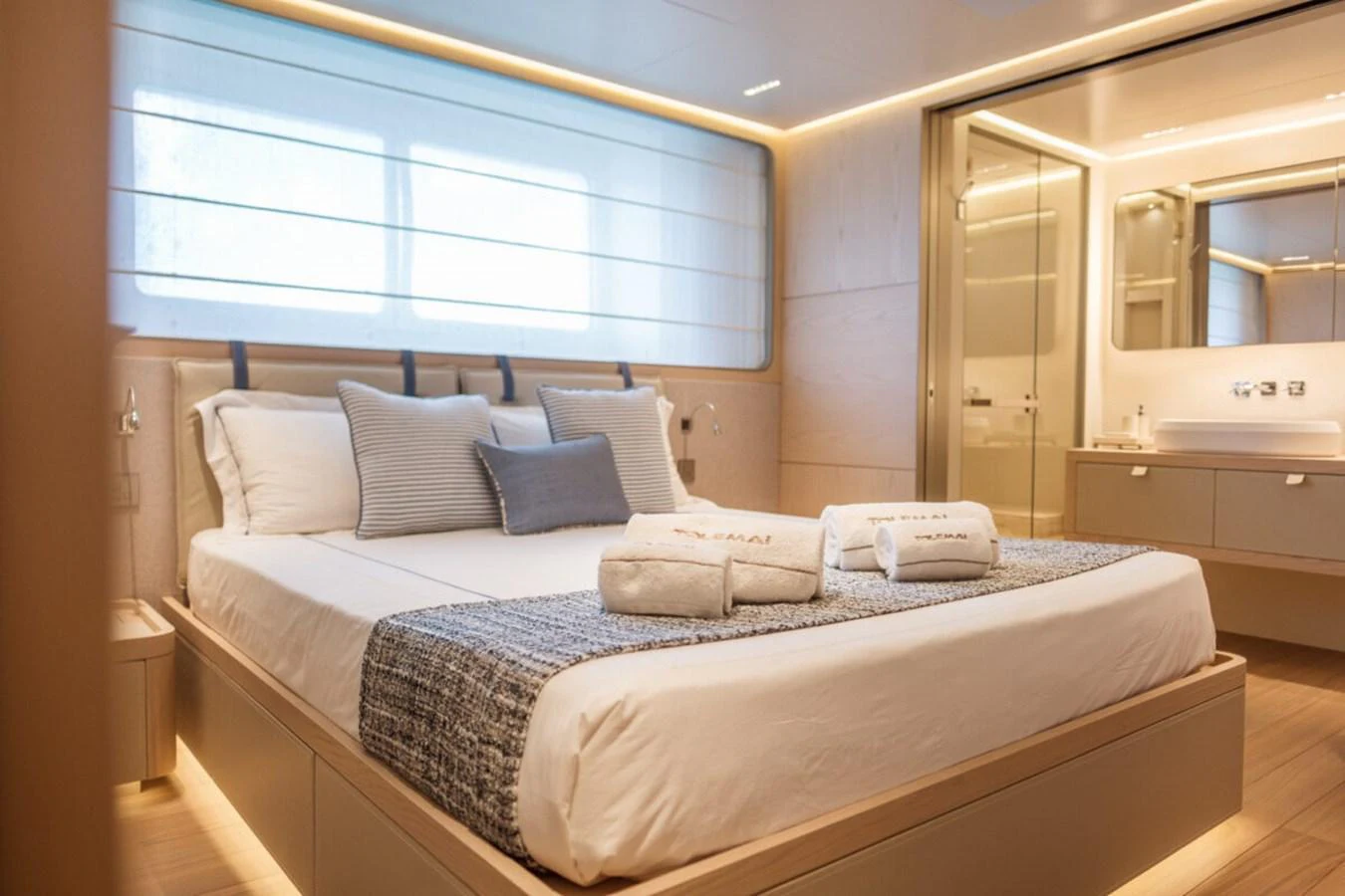 The stateroom features a luxurious bed with elegant linens and ample natural light. aboard TOLEMAI Yacht for Sale