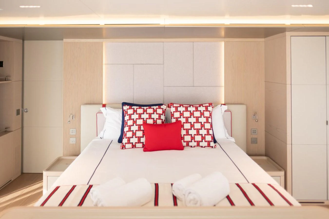 The master stateroom features a luxurious bed with stylish red and white accents, creating a serene and inviting atmosphere. aboard TOLEMAI Yacht for Sale