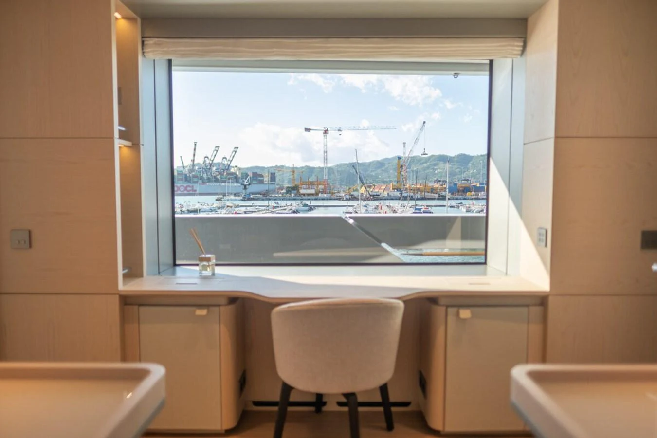 A serene interior space with a large window offering a view of the harbor. aboard TOLEMAI Yacht for Sale