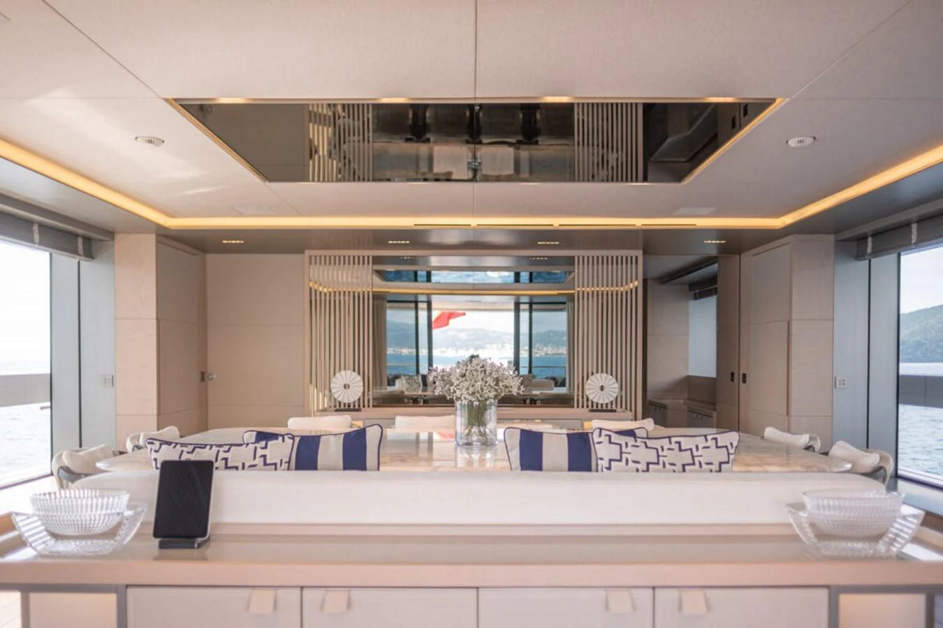 The yacht's salon features elegant decor with plush seating and panoramic windows offering stunning sea views. aboard TOLEMAI Yacht for Sale