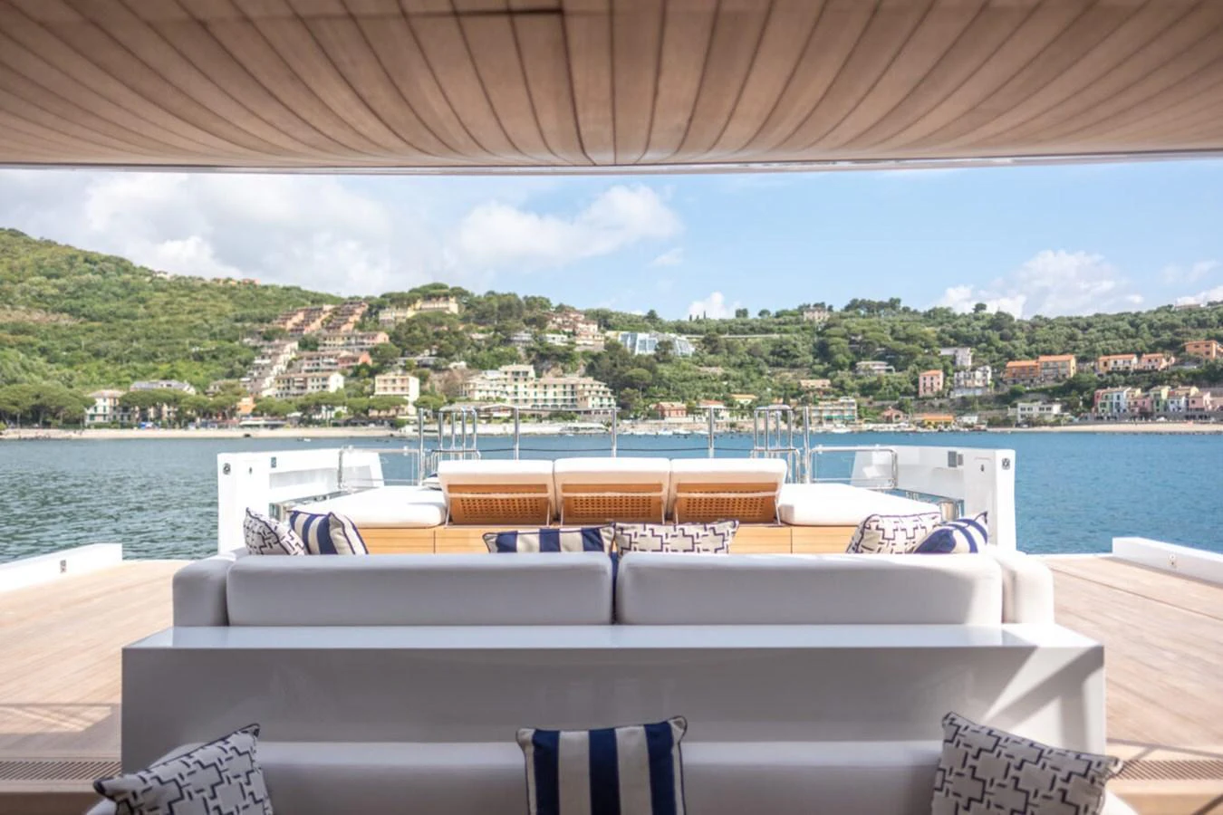 The aft deck offers a luxurious seating area with stunning views of the coastline. aboard TOLEMAI Yacht for Sale