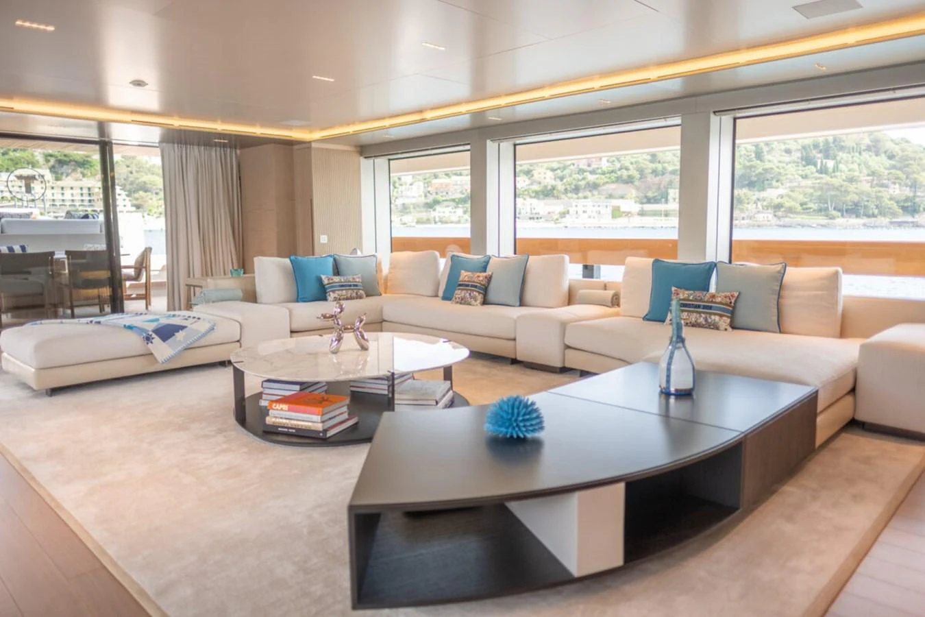 The salon offers a spacious and elegantly designed seating area with large windows providing stunning views. aboard TOLEMAI Yacht for Sale