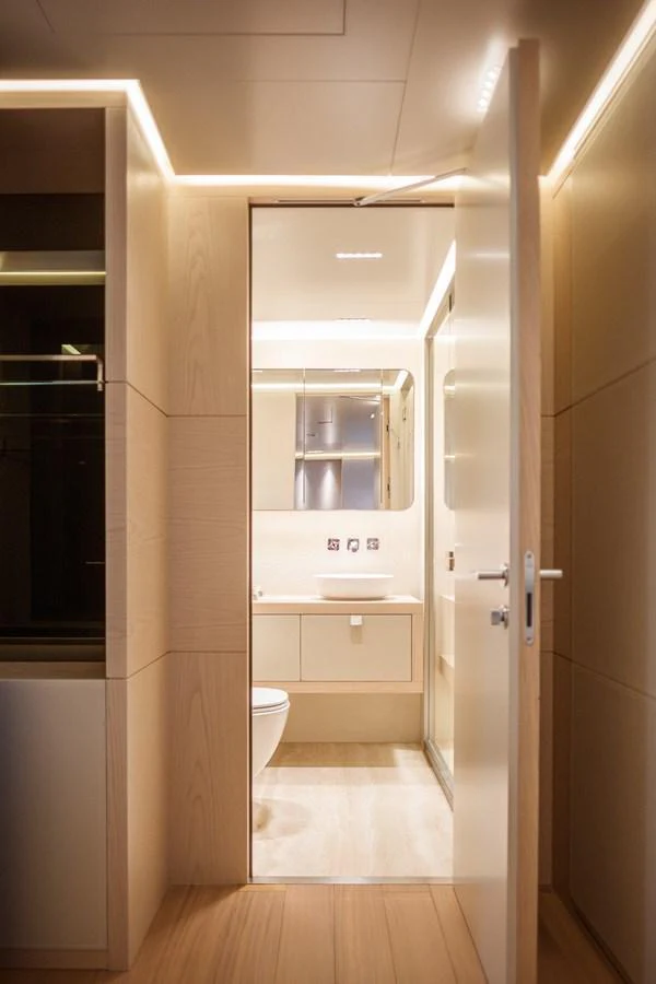 The yacht's bathroom features sleek, modern design with warm lighting and high-quality finishes. aboard TOLEMAI Yacht for Sale