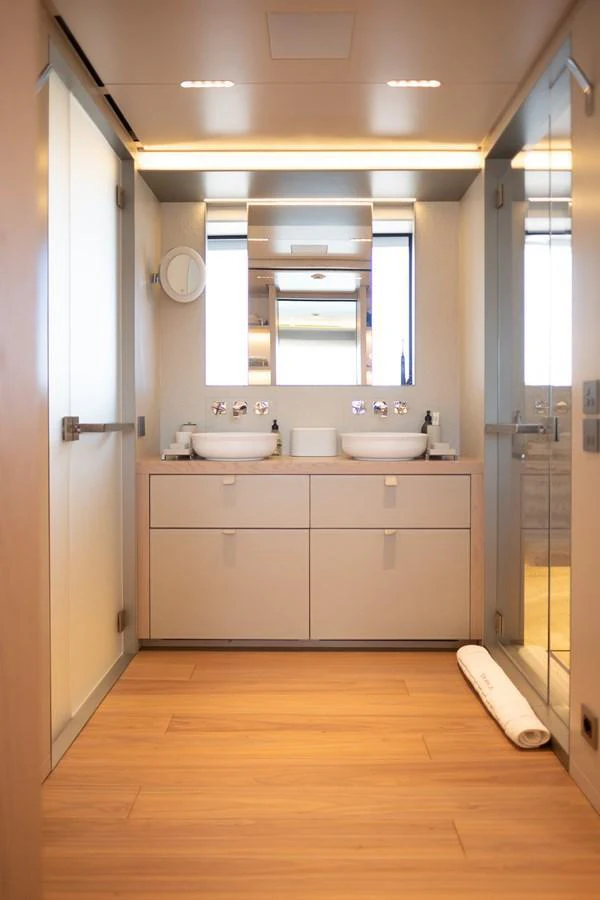 A modern and elegant yacht bathroom with twin sinks and ample storage. aboard TOLEMAI Yacht for Sale