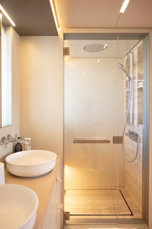 A modern yacht bathroom featuring a glass-enclosed shower and stylish fixtures. aboard TOLEMAI Yacht for Sale