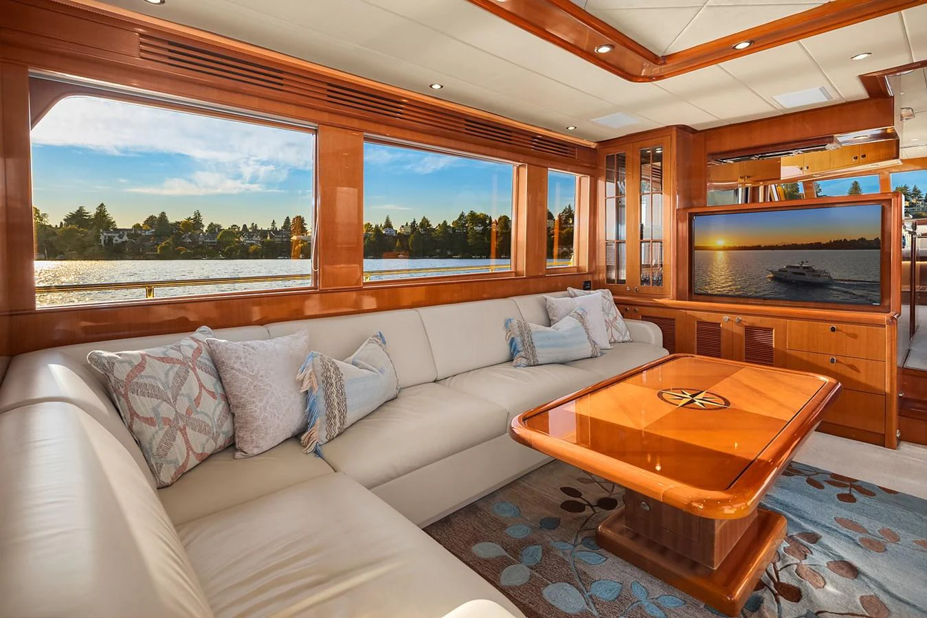 The salon features a spacious and elegant seating area with large windows offering stunning water views. aboard LA BELLA VITA II Yacht for Sale