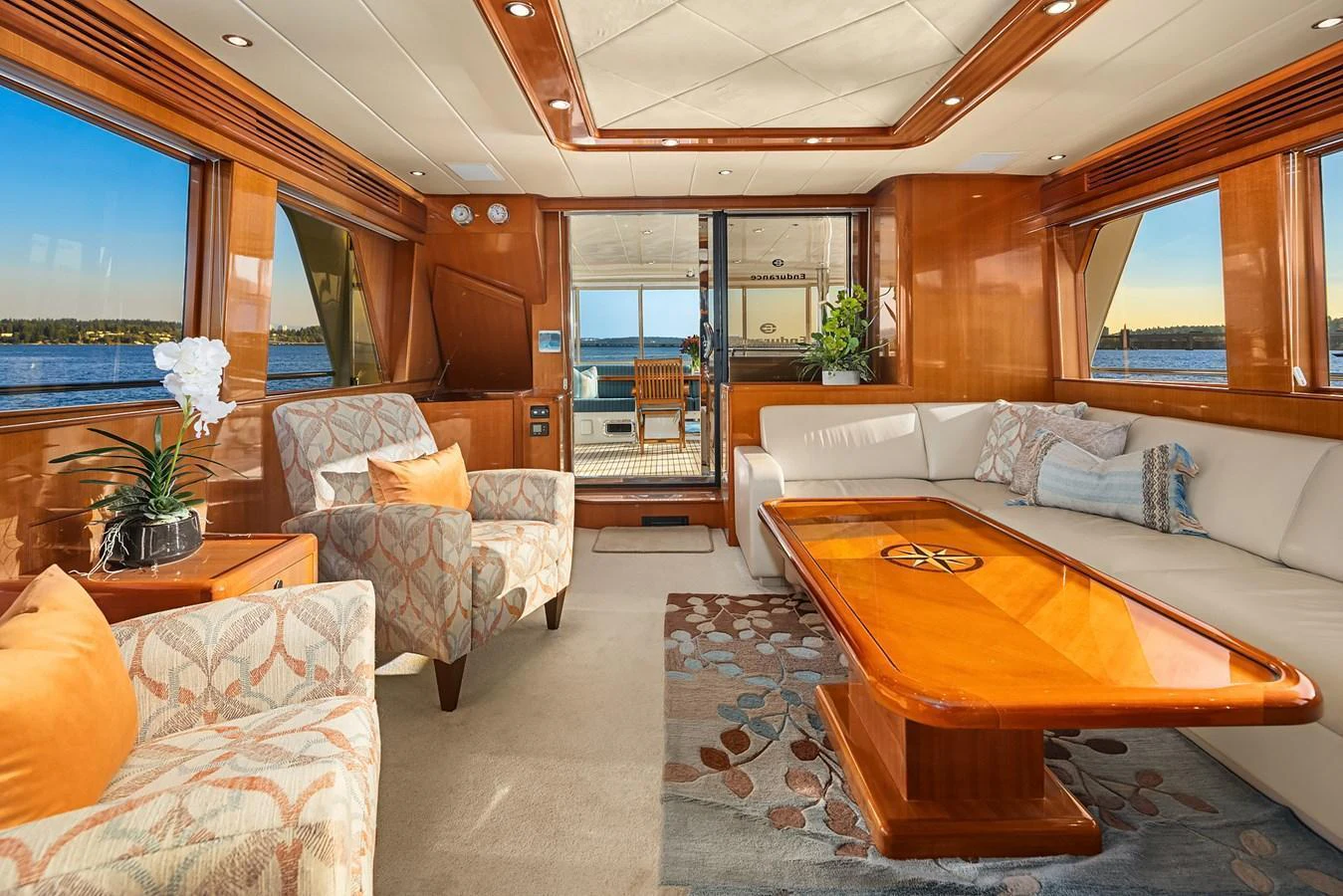 The salon features luxurious seating with elegant wood finishes and panoramic windows offering stunning views. aboard LA BELLA VITA II Yacht for Sale