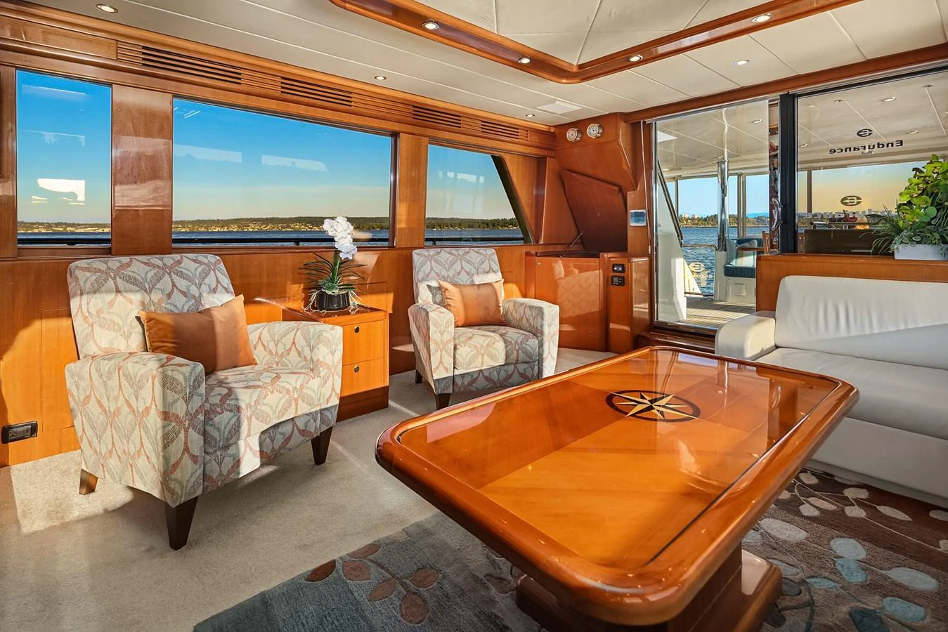 The salon features plush seating, a polished wooden table, and expansive windows offering stunning views. aboard LA BELLA VITA II Yacht for Sale