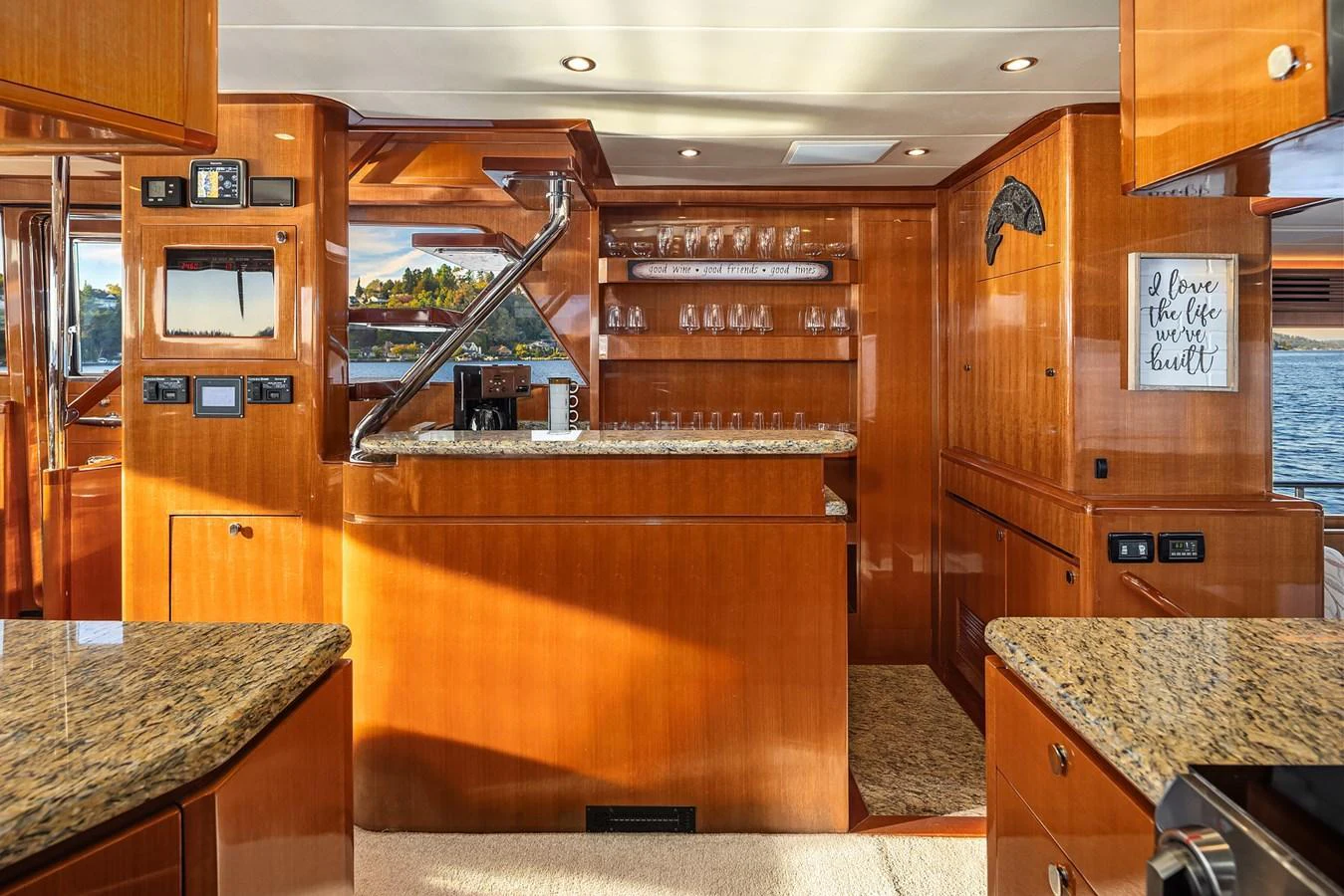 The yacht's galley features polished wood cabinetry, granite countertops, and ample glassware storage. aboard LA BELLA VITA II Yacht for Sale