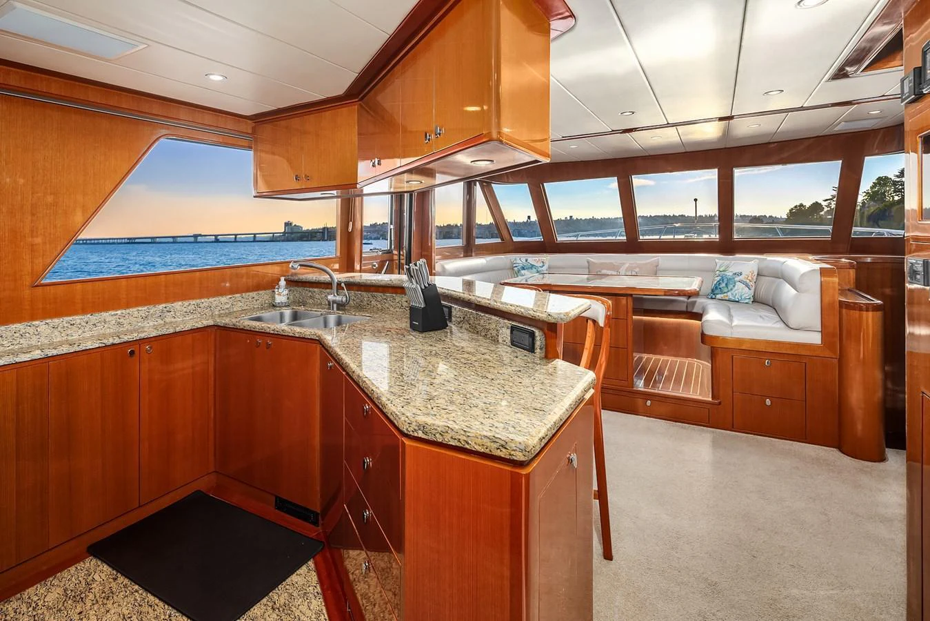 The yacht's galley features elegant wooden cabinetry and granite countertops, with a spacious seating area offering panoramic views. aboard LA BELLA VITA II Yacht for Sale