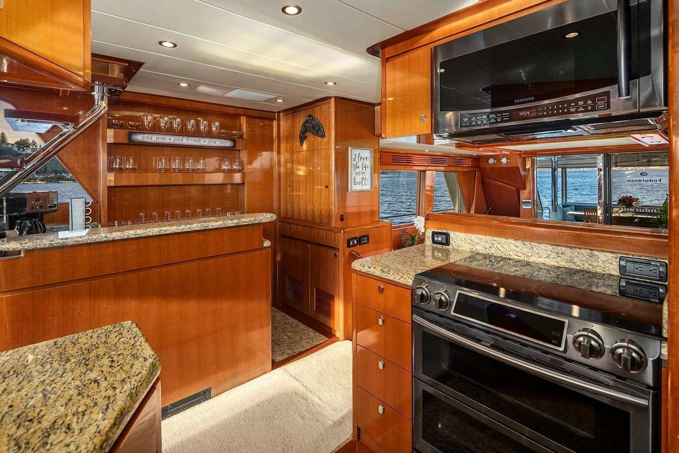 The yacht's galley features modern appliances and elegant wood finishes, providing a luxurious cooking space with a view of the water. aboard LA BELLA VITA II Yacht for Sale