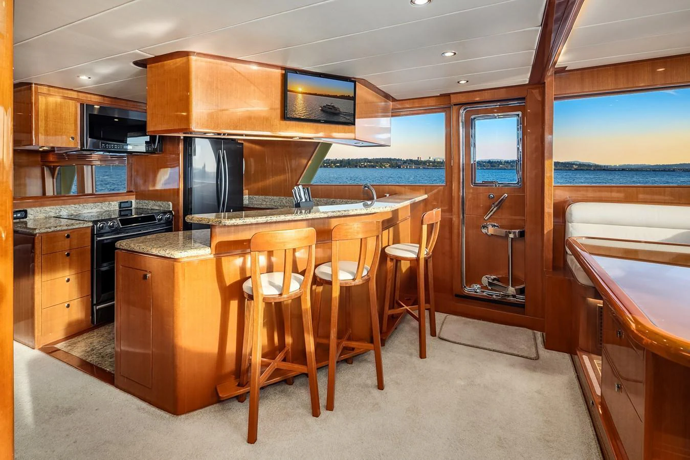 The yacht's galley features a sleek design with a breakfast bar and panoramic windows offering stunning sea views. aboard LA BELLA VITA II Yacht for Sale