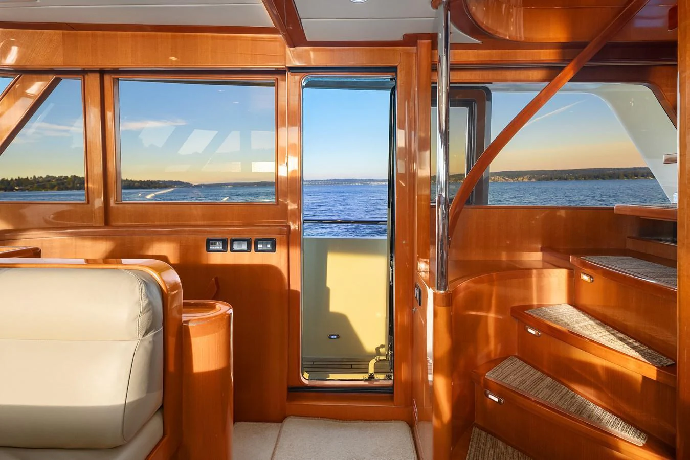 The salon features warm wood finishes, a comfortable seating area, and large windows offering stunning sea views. aboard LA BELLA VITA II Yacht for Sale