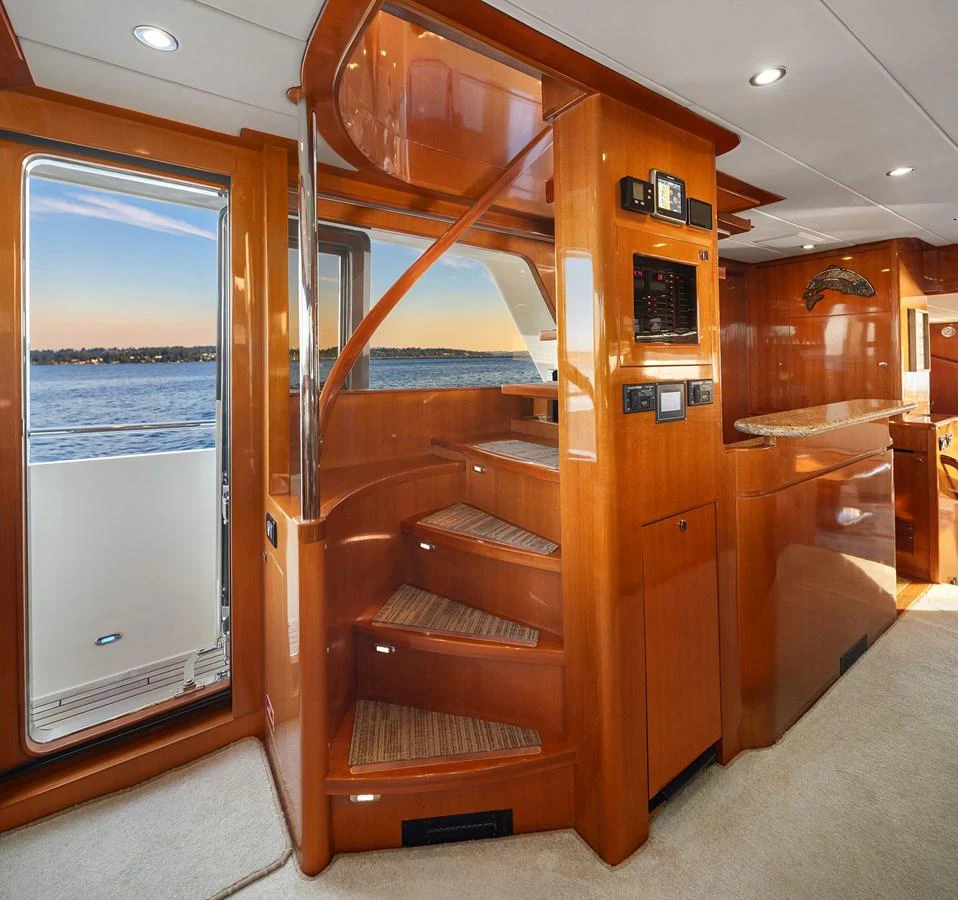 The interior features a beautifully crafted wooden staircase leading to the upper deck. aboard LA BELLA VITA II Yacht for Sale