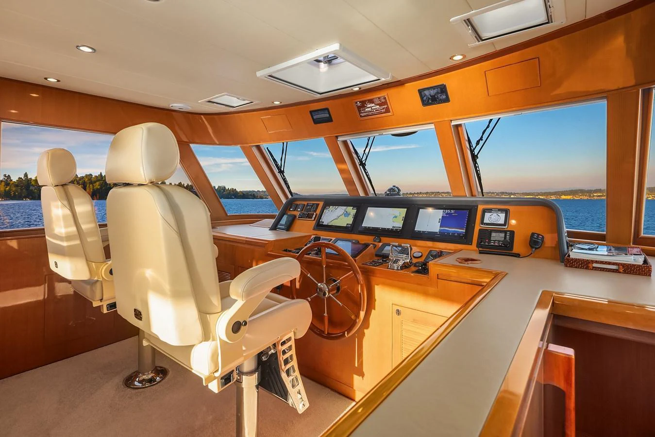The helm of the yacht features luxurious leather seating and state-of-the-art navigation equipment, bathed in warm natural light. aboard LA BELLA VITA II Yacht for Sale