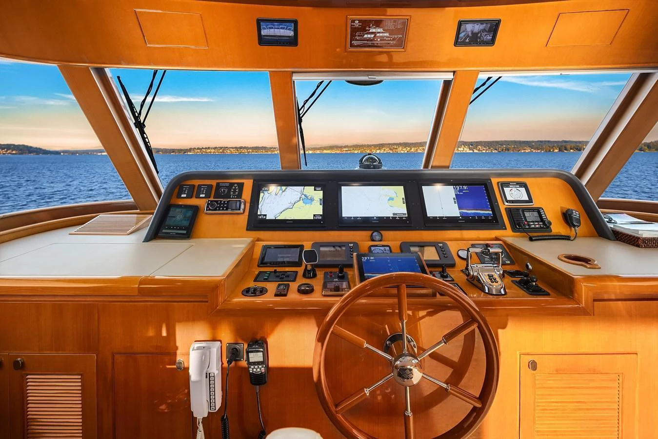 The helm station offers a commanding view with state-of-the-art navigation equipment and a classic wooden steering wheel. aboard LA BELLA VITA II Yacht for Sale