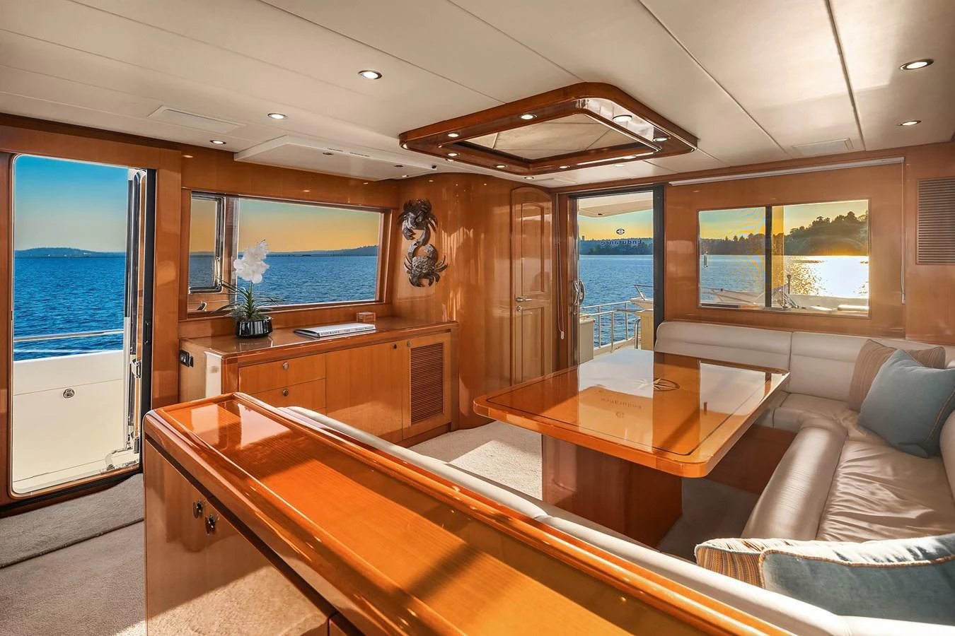 The salon features elegant wood finishes and large windows offering stunning ocean views. aboard LA BELLA VITA II Yacht for Sale