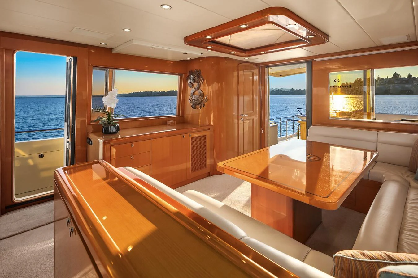 The salon features elegant wood finishes, plush seating, and expansive windows offering stunning ocean views. aboard LA BELLA VITA II Yacht for Sale