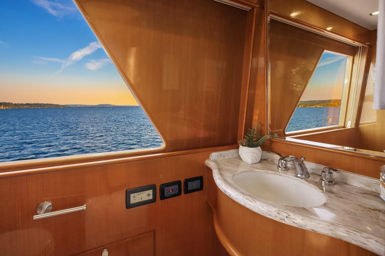 The yacht's bathroom features a sleek marble countertop and large windows offering stunning sea views. aboard LA BELLA VITA II Yacht for Sale