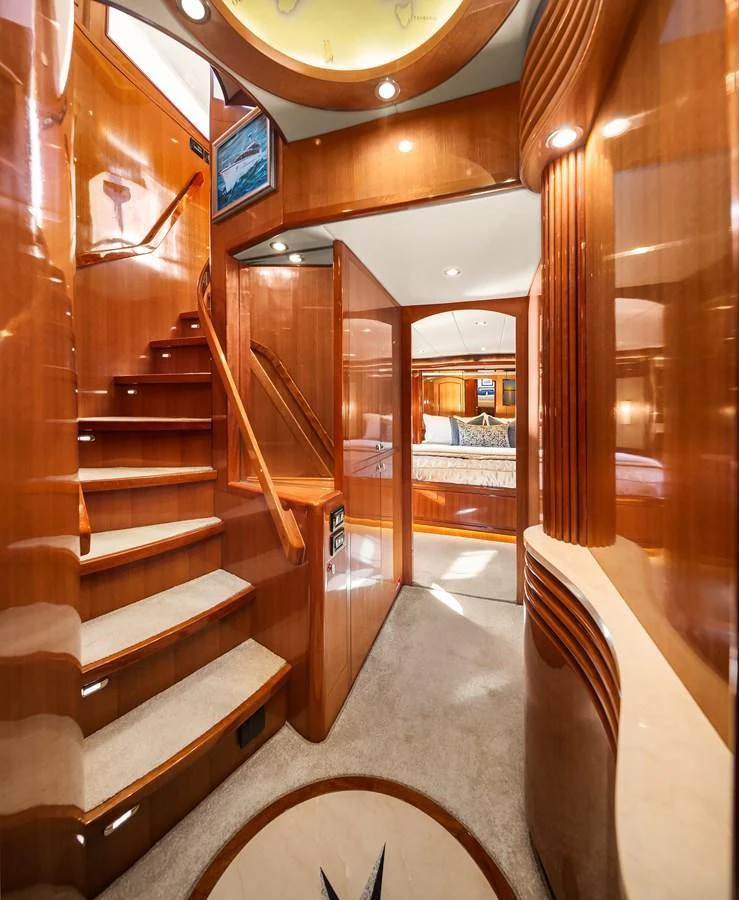 A luxurious interior staircase with polished wood finishes leads to a cozy stateroom. aboard LA BELLA VITA II Yacht for Sale
