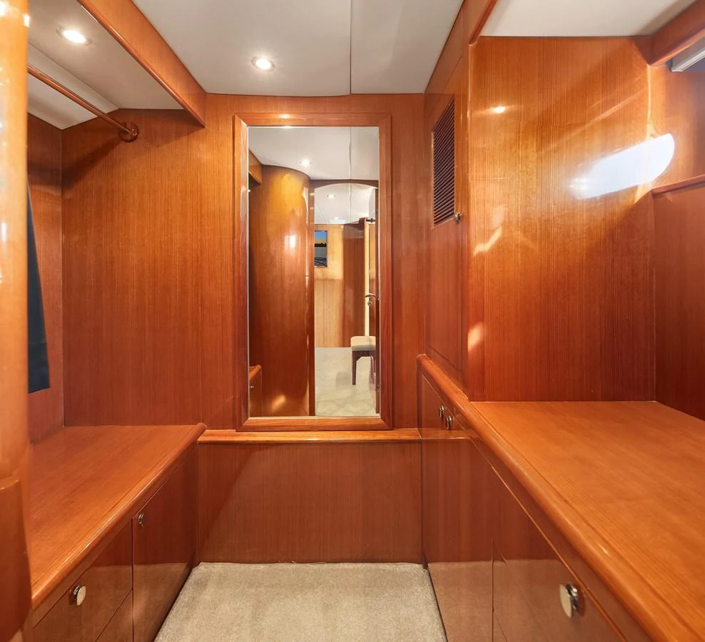 A well-appointed interior space featuring warm wood paneling and a large mirror. aboard LA BELLA VITA II Yacht for Sale