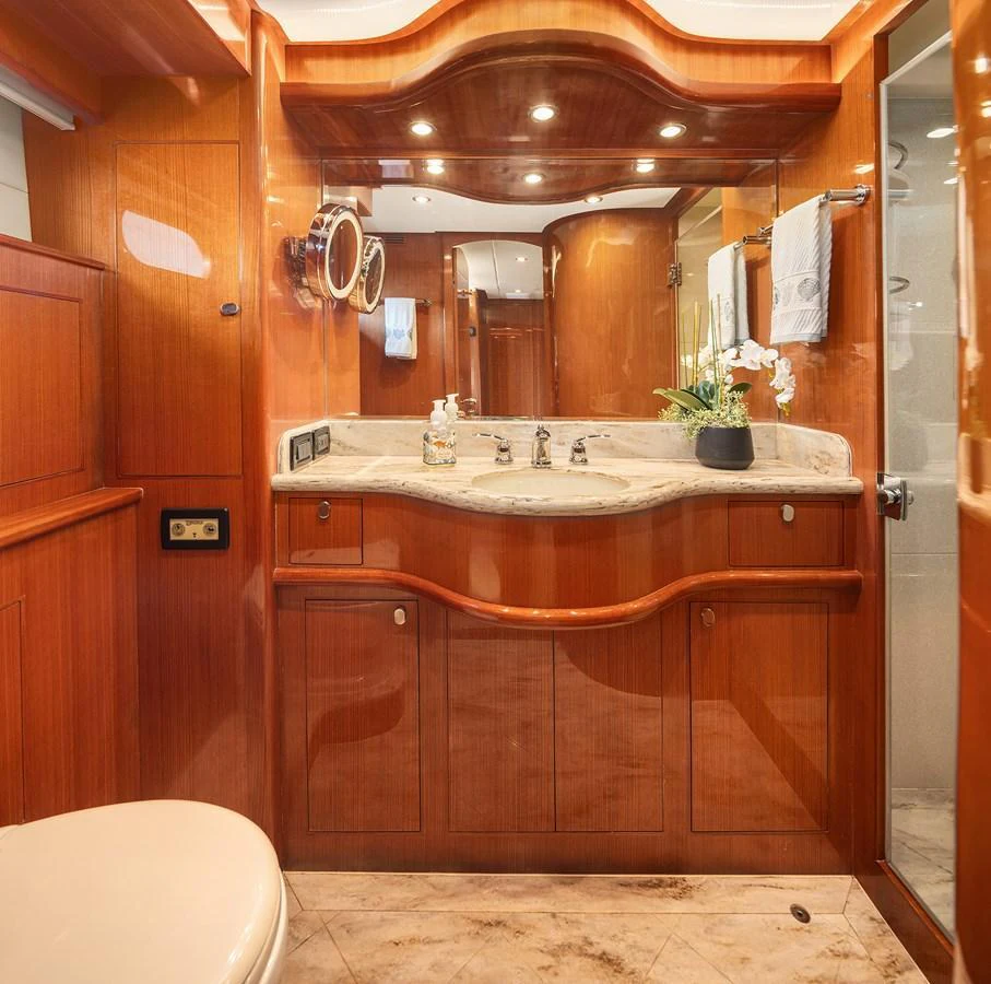 The yacht's bathroom features elegant wood paneling and a marble countertop, creating a luxurious and warm atmosphere. aboard LA BELLA VITA II Yacht for Sale