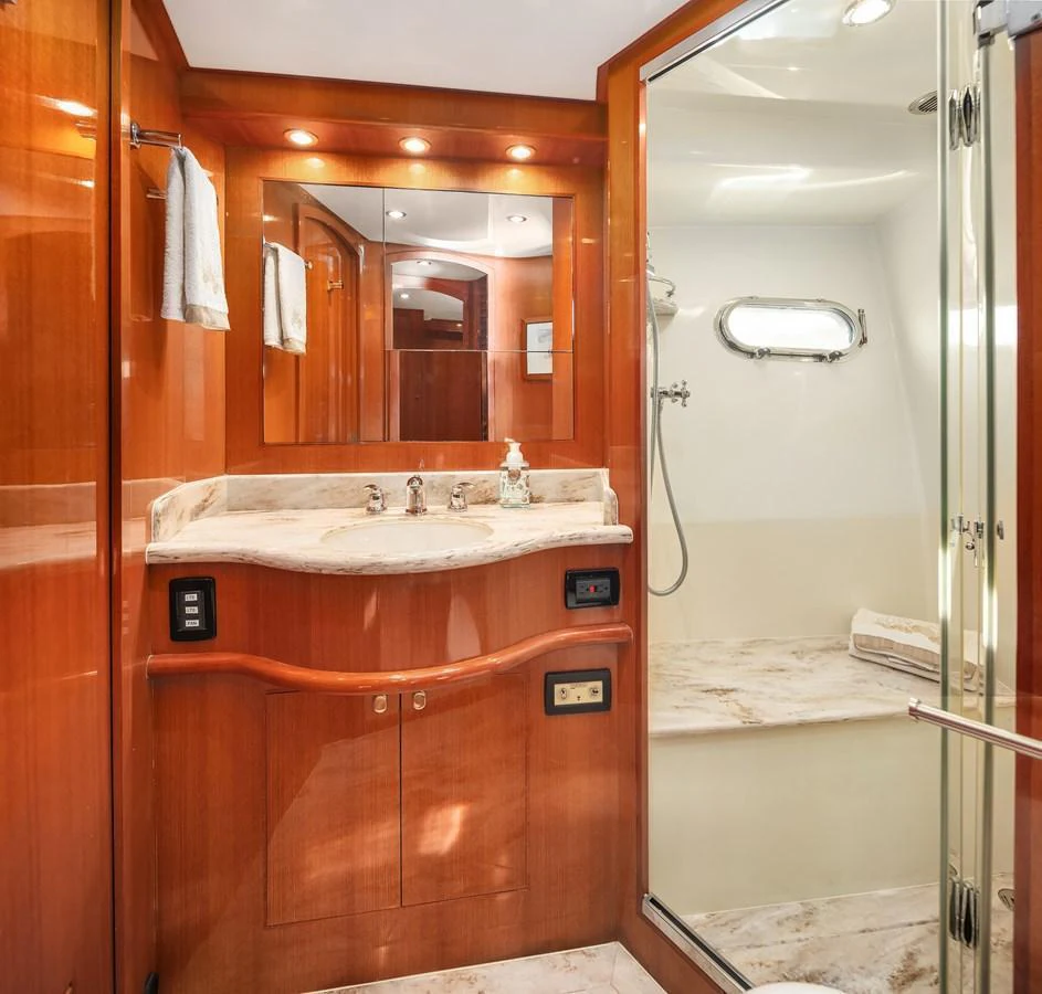 The yacht's bathroom features elegant wood finishes and a spacious shower area. aboard LA BELLA VITA II Yacht for Sale