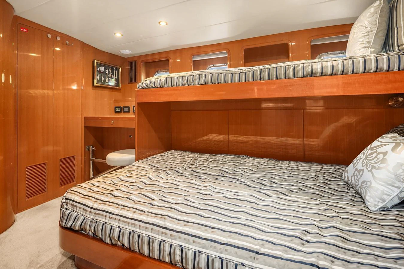The guest stateroom features cozy bunk beds with striped bedding and warm wood paneling. aboard LA BELLA VITA II Yacht for Sale