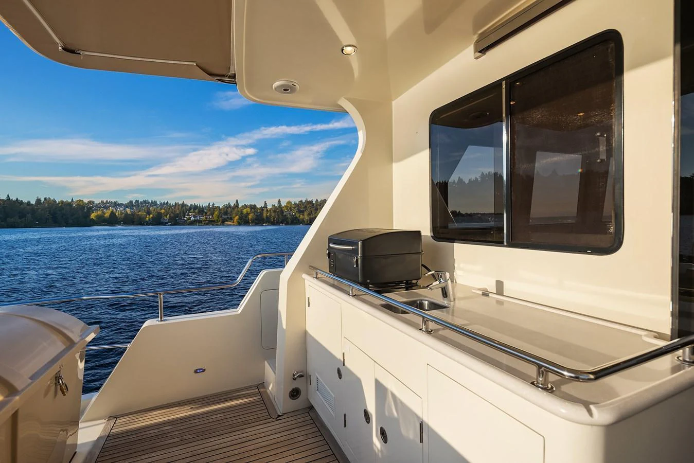 The aft deck features a sleek outdoor kitchen area with a scenic view of the water. aboard LA BELLA VITA II Yacht for Sale