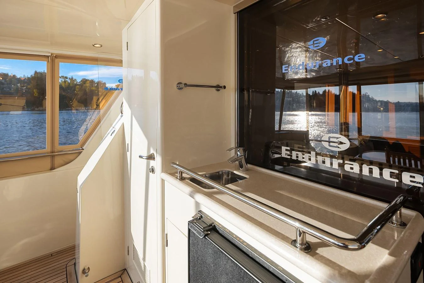 The yacht's interior features a compact and functional galley area with a sink and storage space, complemented by large windows offering scenic water views. aboard LA BELLA VITA II Yacht for Sale