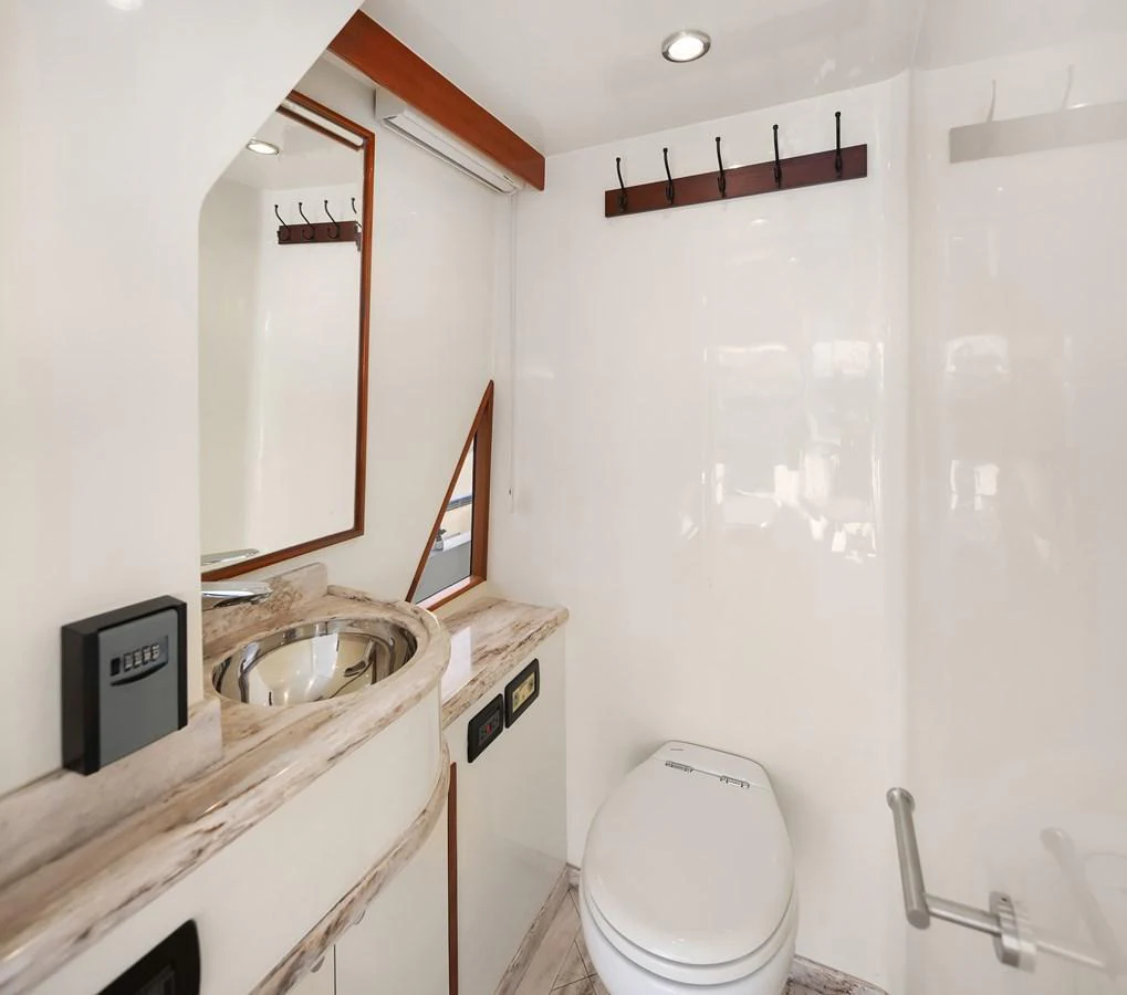 The yacht's head features a modern design with a sleek sink and a well-appointed toilet. aboard LA BELLA VITA II Yacht for Sale