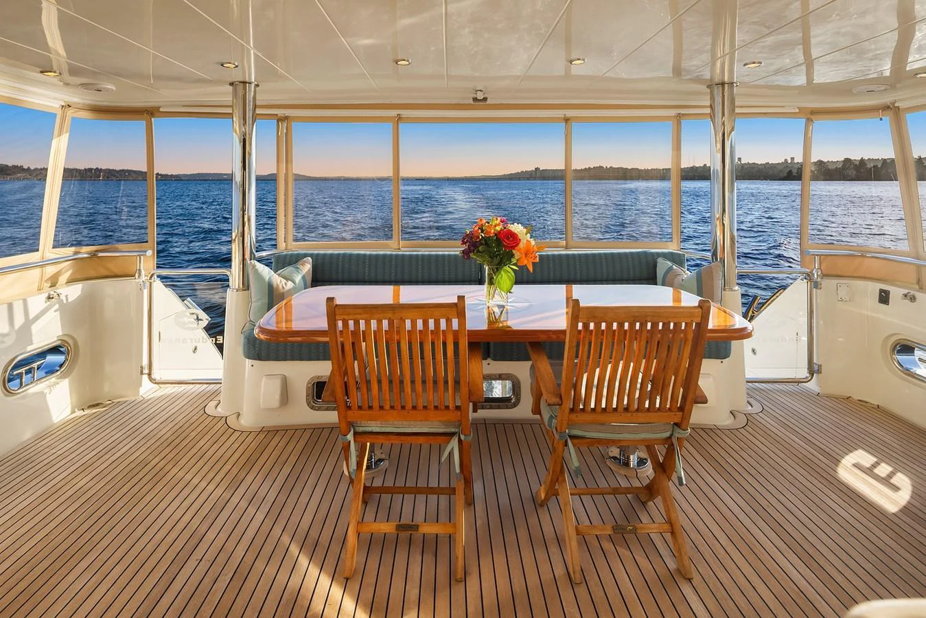The aft deck features a cozy dining area with a stunning view of the water. aboard LA BELLA VITA II Yacht for Sale