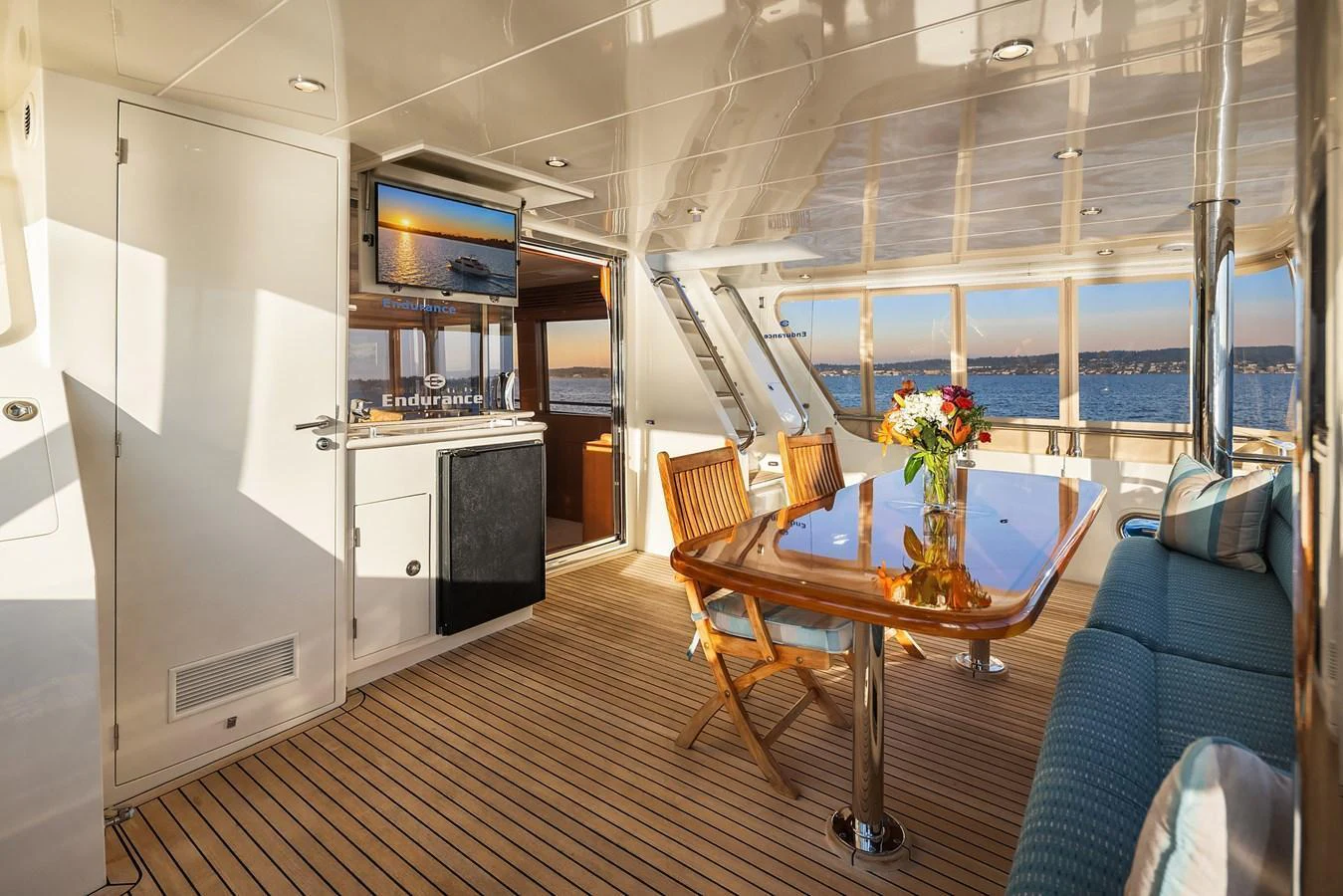 The salon features a spacious seating area with a dining table and panoramic windows offering stunning sea views. aboard LA BELLA VITA II Yacht for Sale