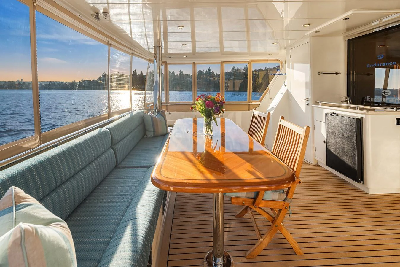 The aft deck features a comfortable seating area with a wooden table, perfect for enjoying the view. aboard LA BELLA VITA II Yacht for Sale