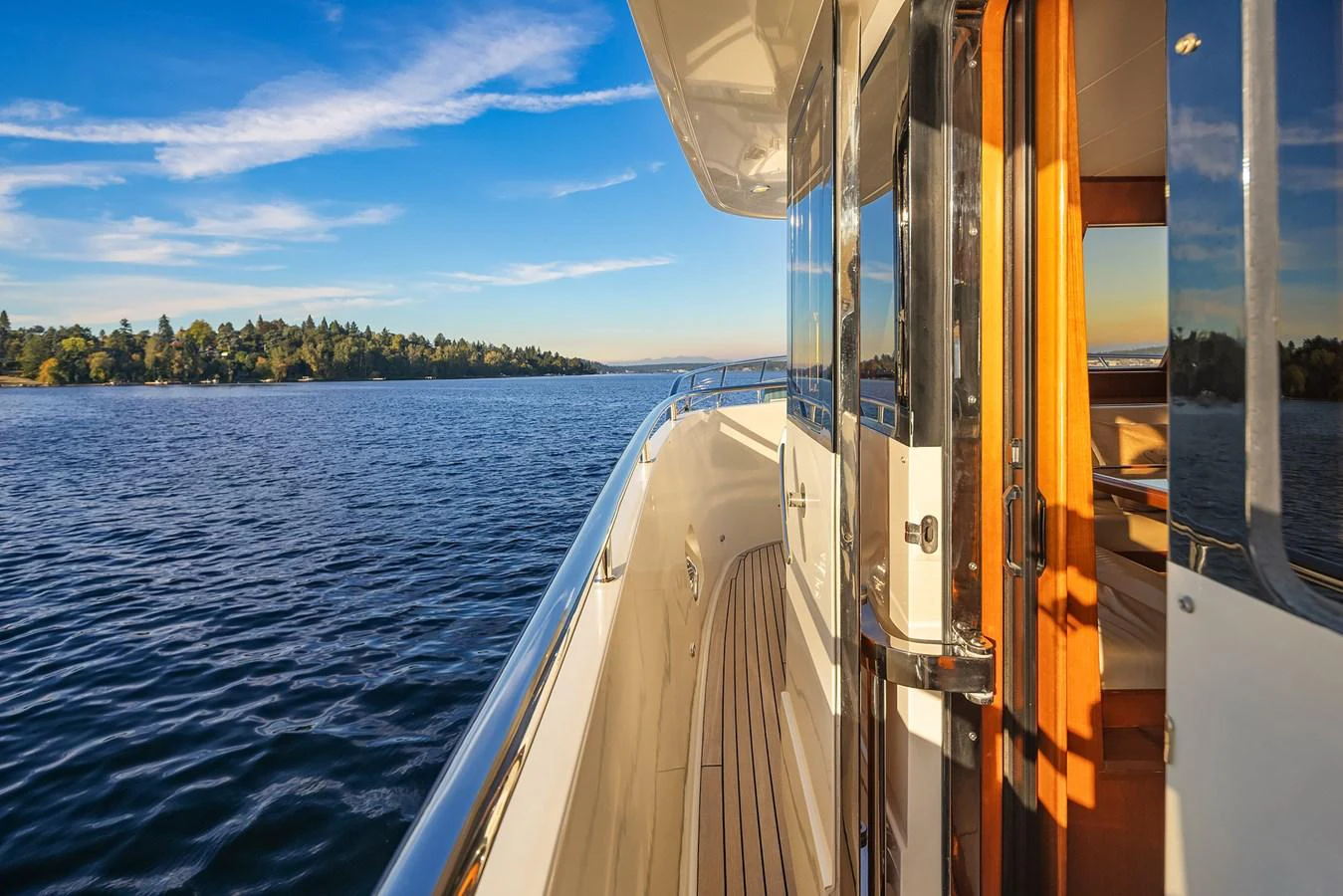 A serene view from the side deck of a yacht, showcasing the tranquil waters and distant shoreline. aboard LA BELLA VITA II Yacht for Sale