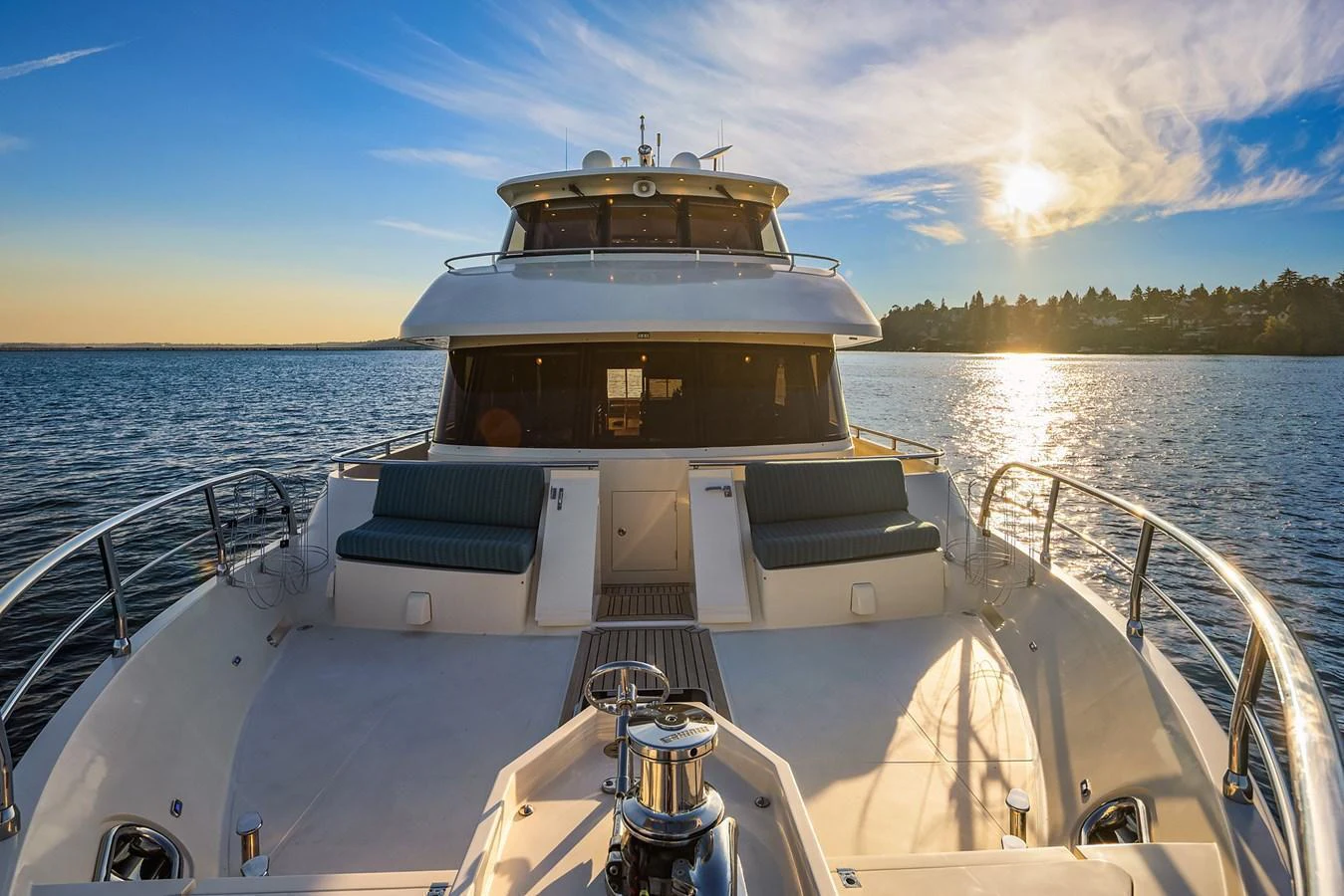 The yacht's bow area is beautifully illuminated by the setting sun, showcasing comfortable seating and a spacious deck. aboard LA BELLA VITA II Yacht for Sale