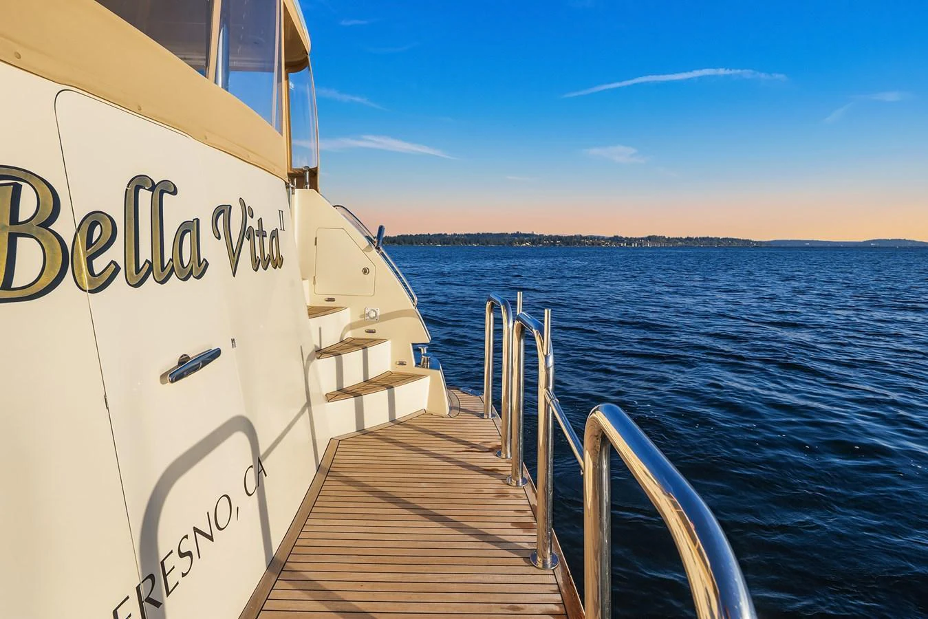 The yacht's aft deck offers a serene view of the open water under a clear sky. aboard LA BELLA VITA II Yacht for Sale