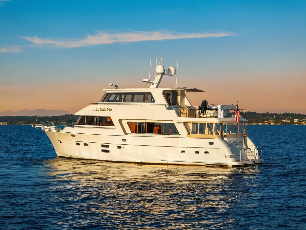 A luxurious yacht cruises gracefully on calm waters during a beautiful sunset. aboard LA BELLA VITA II Yacht for Sale