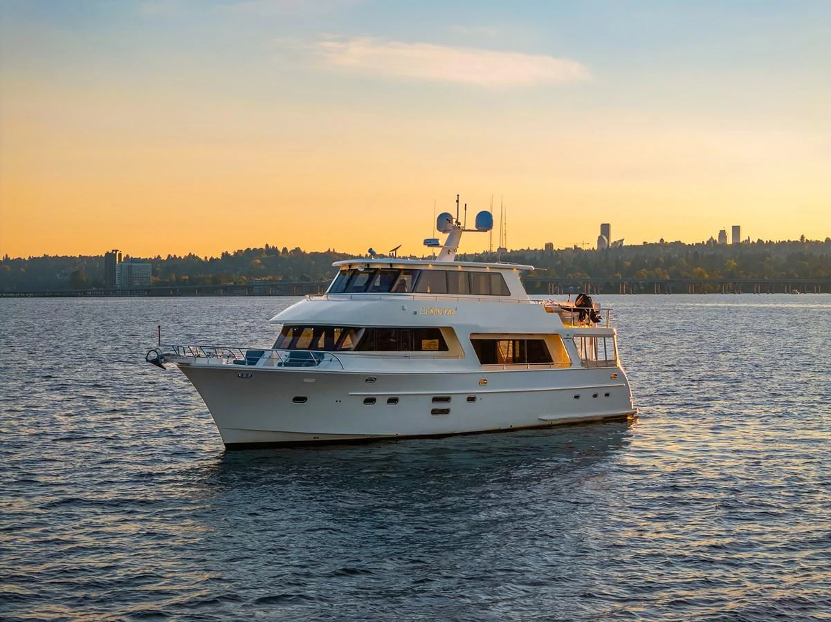 A luxurious yacht cruises serenely on calm waters against a picturesque sunset backdrop. aboard LA BELLA VITA II Yacht for Sale