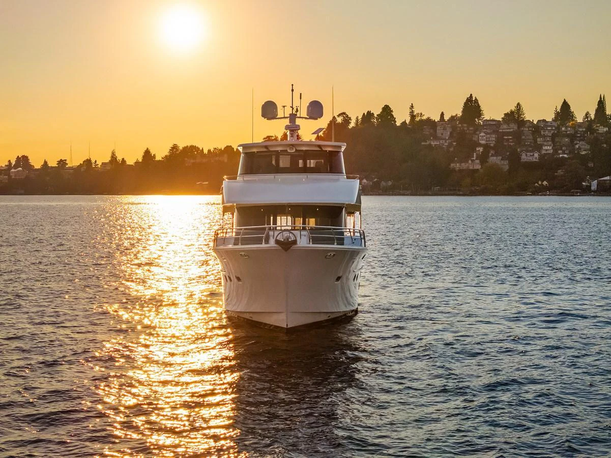 A stunning yacht is captured head-on at sunset, gliding gracefully on calm waters. aboard LA BELLA VITA II Yacht for Sale