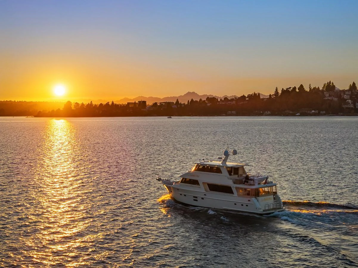 A luxurious yacht cruises on calm waters during a stunning sunset. aboard LA BELLA VITA II Yacht for Sale