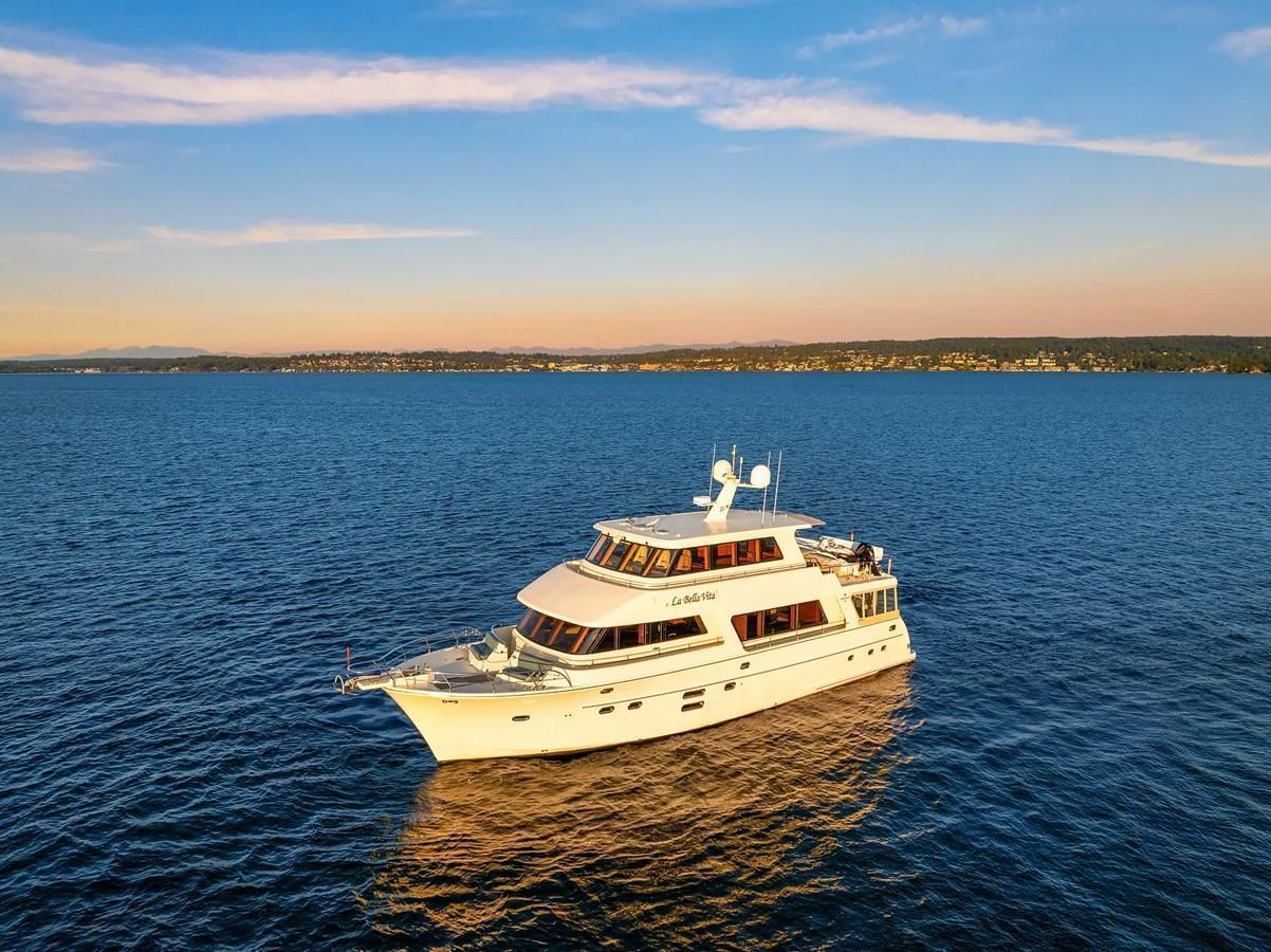 A luxurious yacht cruises serenely on calm waters under a clear sky. aboard LA BELLA VITA II Yacht for Sale