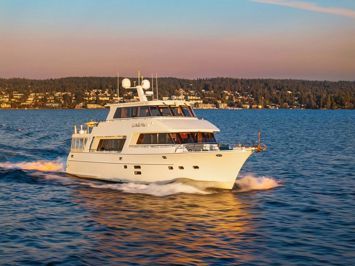 A luxurious yacht cruises smoothly on calm waters during a picturesque sunset. aboard LA BELLA VITA II Yacht for Sale