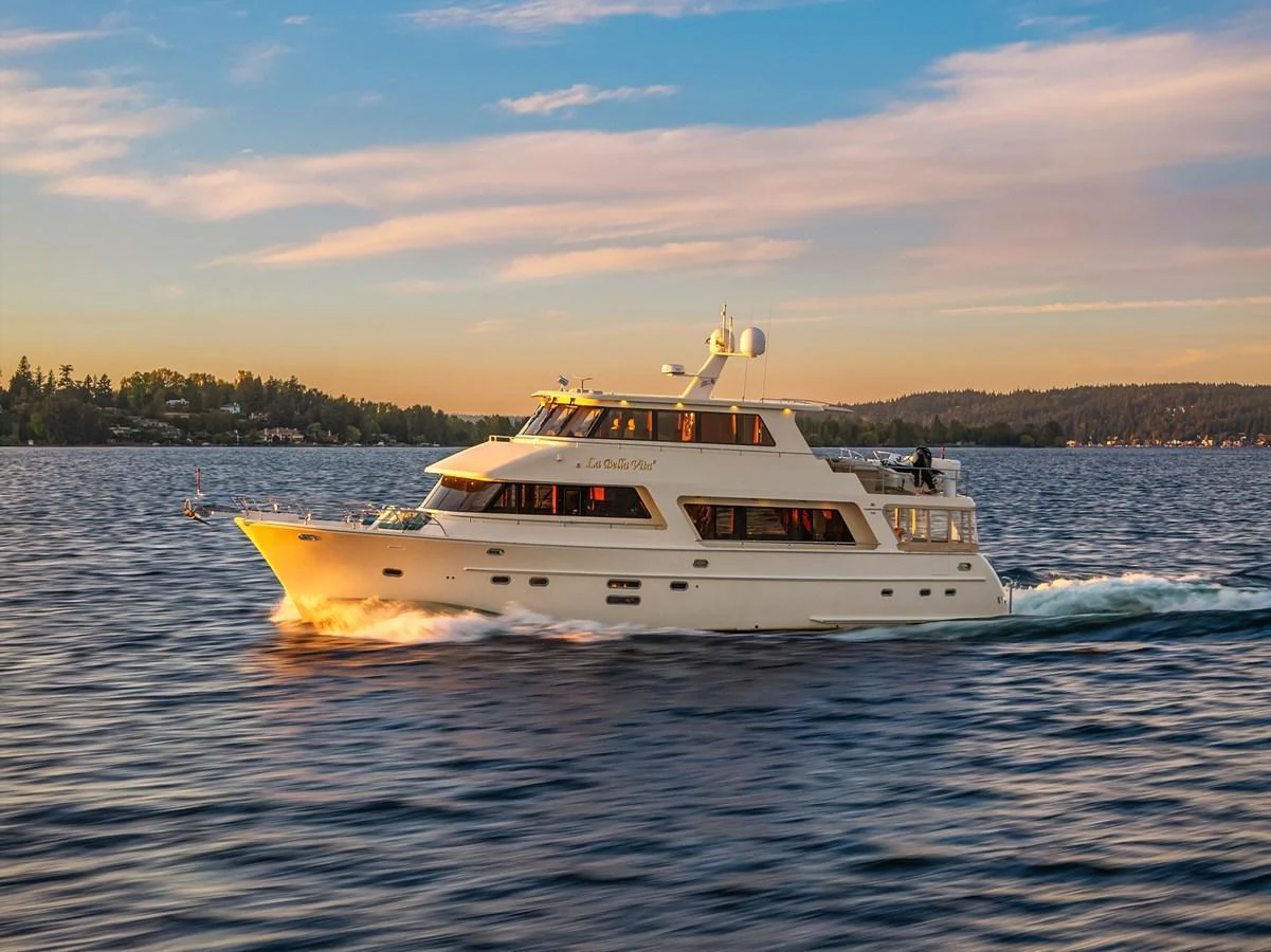 A luxurious yacht cruises gracefully on calm waters during a picturesque sunset. aboard LA BELLA VITA II Yacht for Sale