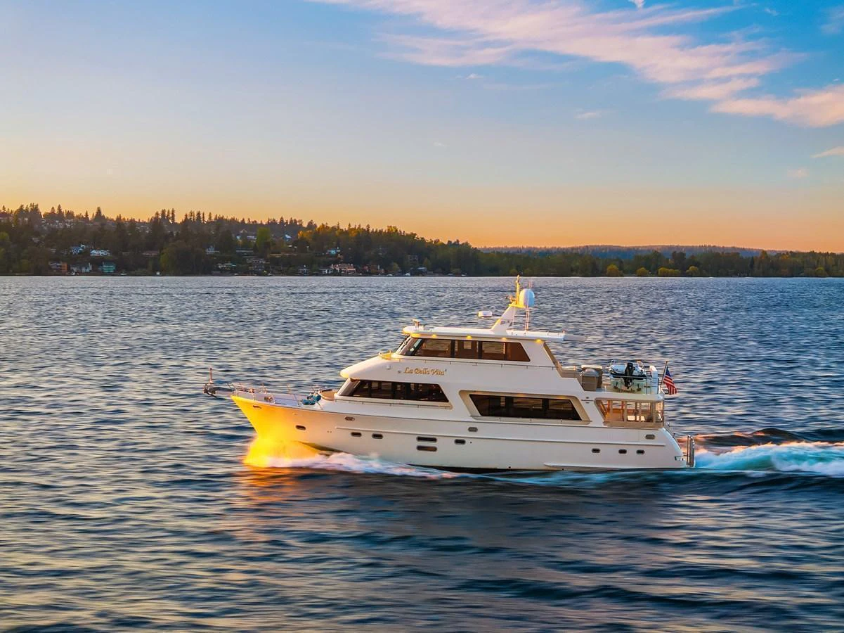 A luxurious yacht cruises through serene waters at sunset, showcasing its elegant design and spacious decks. aboard LA BELLA VITA II Yacht for Sale