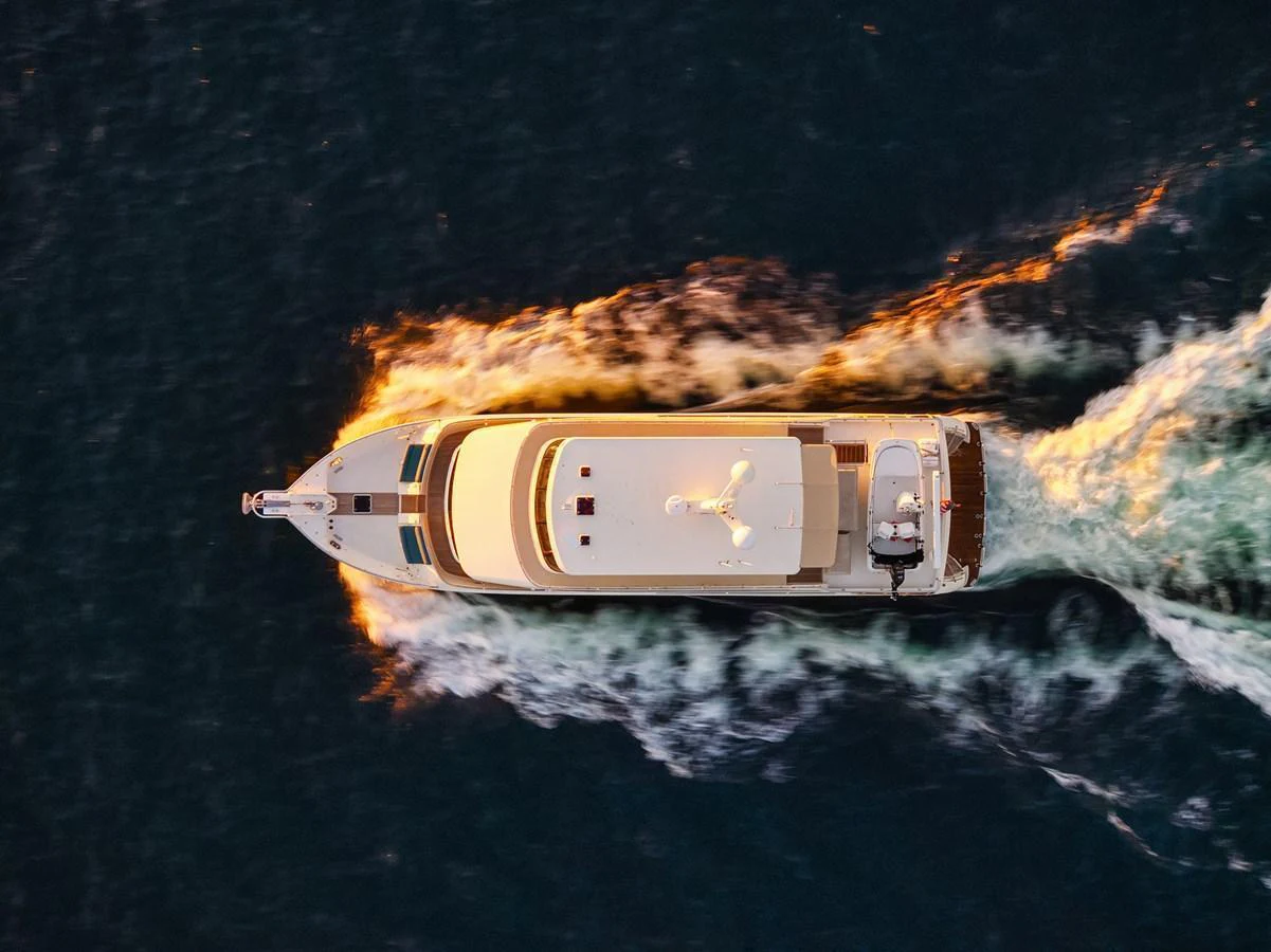 An aerial view of a luxurious yacht cruising through the water at sunset. aboard LA BELLA VITA II Yacht for Sale
