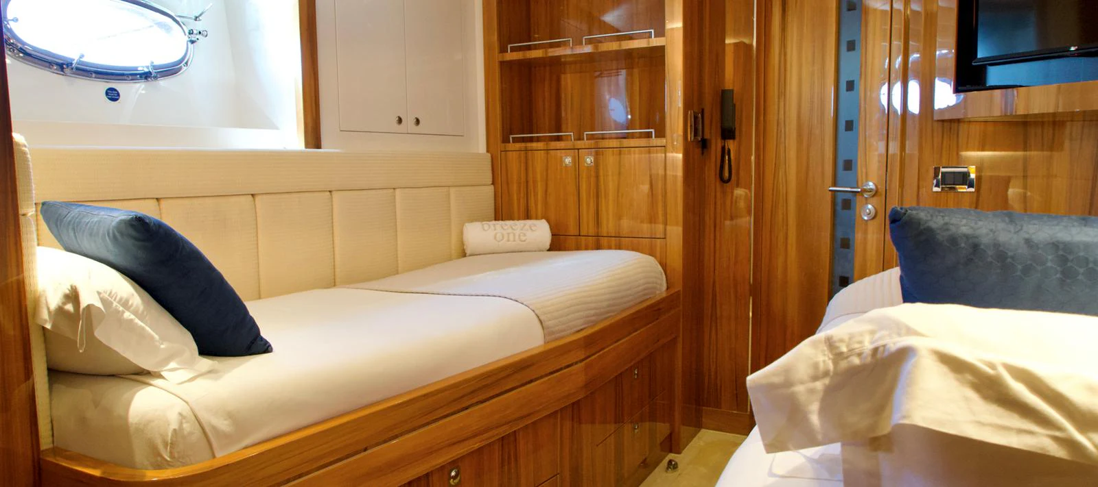 The guest stateroom features cozy twin beds with elegant wood paneling and soft lighting. aboard SEA BREEZE ONE Yacht for Sale