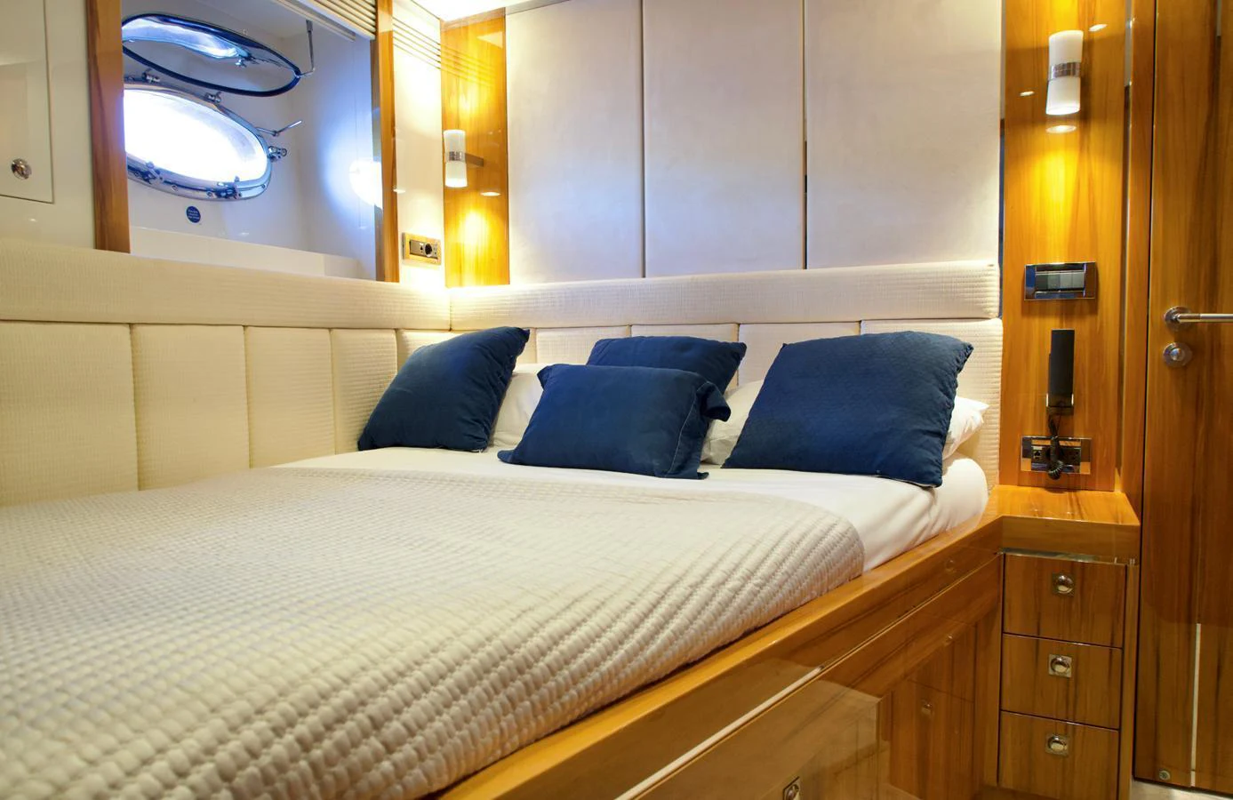 The stateroom features a cozy bed with plush pillows and elegant wooden finishes. aboard SEA BREEZE ONE Yacht for Sale