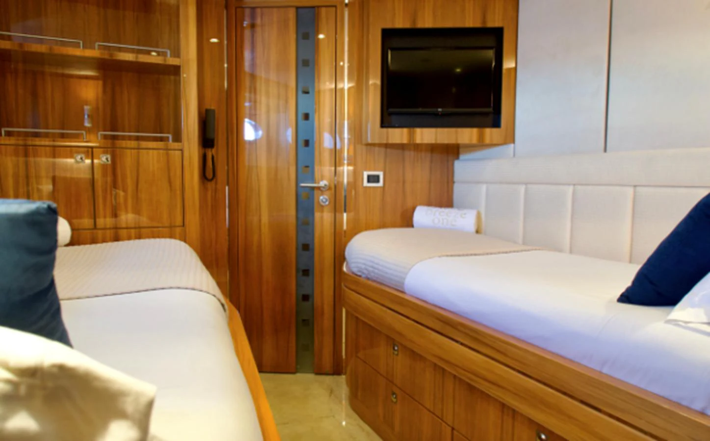 The guest cabin features twin beds with elegant wood paneling and modern amenities. aboard SEA BREEZE ONE Yacht for Sale