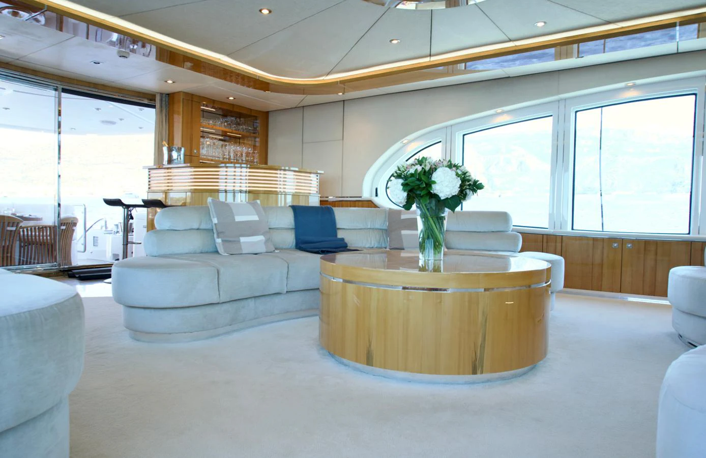 The salon features plush seating, a round coffee table, and large windows for natural light. aboard SEA BREEZE ONE Yacht for Sale